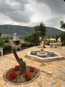 奥里库姆Vila RESA - Intero allogio的庭院,设有喷泉,有树和鲜花