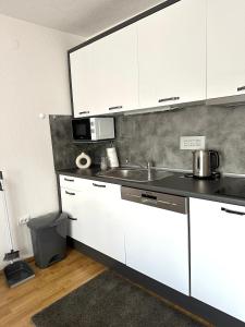 拉克塔希Apartman Lara Laktasi的厨房配有白色橱柜和水槽