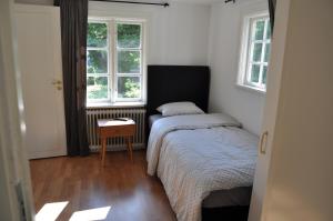 långstorp的一间卧室配有一张床、一张桌子和两个窗户