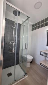 圣玛丽亚港TU DENSCANSO EN VALDELAGRANA FRENTE AL MAR的一间带卫生间的浴室内的玻璃淋浴间