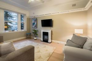 悉尼Best location in Manly Harbour view的一间带电视和壁炉的客厅