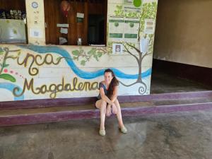 BalgueFinca Magdalena Eco Lodge的坐在建筑物台阶上的女人