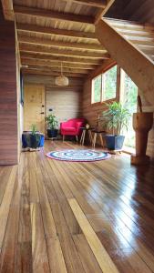 瓜尔内Beehouse Arví Cabaña的客厅设有红色的沙发和木地板