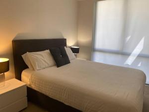 悉尼Ultra Convenient St Leonards Apartment HER09008的卧室配有一张大白色床和窗户