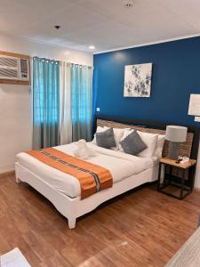伊洛伊洛The New View by Ecotel的一间卧室配有一张带蓝色墙壁的大床