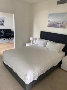 悉尼Stylish two bedroom in St Leonards ALB91105的一间卧室配有一张带白色床单的大床