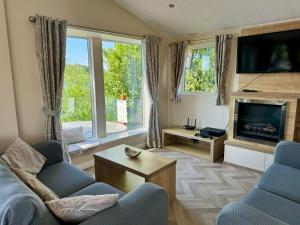 塔特舍尔Fable Lodge Tattershall Lakes - luxury lakeside lodge with hot tub的带沙发和壁炉的客厅