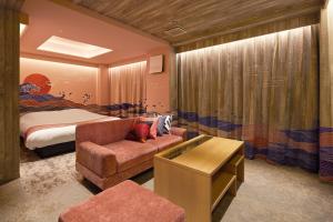 Yatomi Hotel Nuqu Natural Hot Spring的一间卧室配有一张床、一张沙发和一把椅子