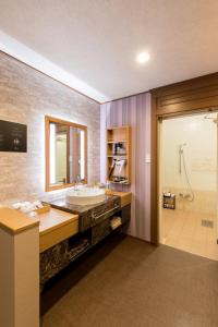 Yatomi Hotel Nuqu Natural Hot Spring的一间带大水槽和淋浴的浴室