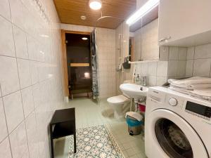 拉赫蒂Kotimaailma Apartments Lahti的一间带洗衣机和水槽的浴室