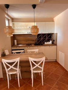 罗佐瓦克Kalpic Suites & Villa的厨房配有木桌和两把椅子