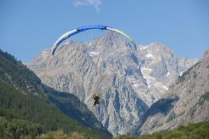 瓦卢伊斯Huttopia Vallouise的挂在山前降落伞的人