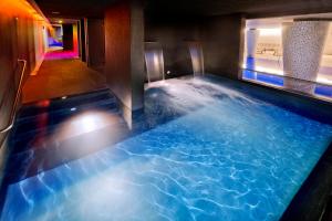 圣苏珊娜AQUA Hotel Onabrava & Spa 4*Sup的蓝色水的酒店客房内的热水浴池