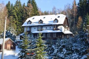 日茄基Hotel Konšel的一座大房子,有雪盖屋顶