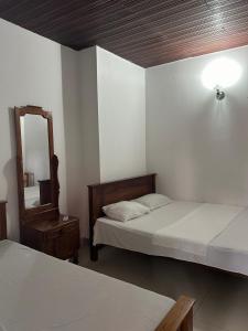代希瓦勒西莫旅馆的一间卧室配有两张床、镜子和灯