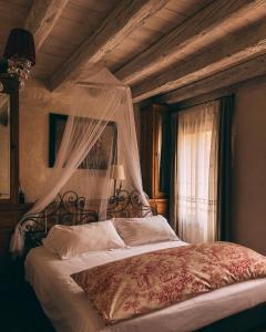 瓦尔多比亚德内Locanda Sandi的一间卧室配有一张带天蓬和窗户的床