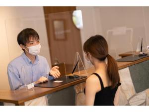 东京Hotel Emit Shibuya - Vacation STAY 40892v的手提电脑上戴面具的男人和女人