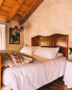 瓦尔多比亚德内Locanda Sandi的一间卧室配有两张带白色床单的床