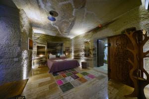 格雷梅Göreme Cave Lodge的卧室配有一张石墙床