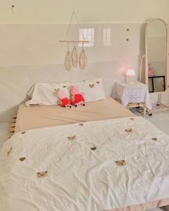 芽庄Homestay Tuyết Trinh的一间卧室配有两张带白色床单和桌子的床
