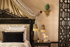 马拉喀什Palais Ronsard Relais & Chateaux的卧室配有黑白床和灯