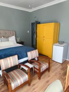 鲁德普特Bird Song的一间卧室配有床、椅子和黄色橱柜