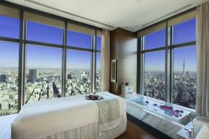 东京Mandarin Oriental, Tokyo的一间卧室配有一张大床、一个浴缸和窗户。