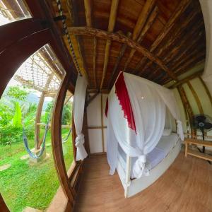 PawenangDe Chicktoria Hostel的客房设有一张带天蓬的床和窗户。