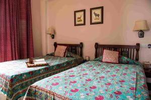 斋浦尔阿里亚尼洼斯酒店的一间卧室配有两张床和一张桌子