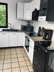 巴特本特海姆FeWo Burgblick - mit Terrasse的厨房配有白色橱柜和黑色冰箱。