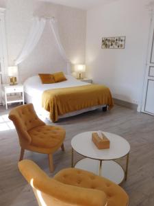 塞里尼亚克Logis Hotel Le Prince Noir的卧室配有1张床、1张桌子和1把椅子