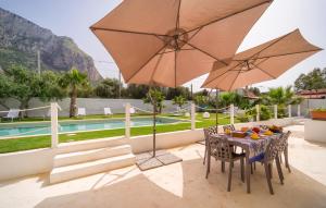 巴勒莫Pet Friendly Home In Palermo With Kitchen的游泳池旁配有桌椅和遮阳伞