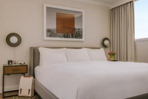 温哥华日落套房酒店的卧室设有一张白色大床和一扇窗户。