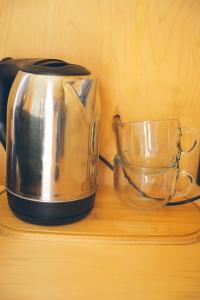 SatyPanorama Glamping的茶壶和木架上的玻璃碗