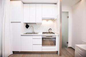 米兰设计公寓 - 米兰市中心 - 大教堂的白色的厨房设有水槽和炉灶。