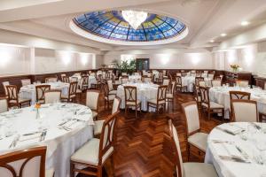 都灵玛杰斯缇克星际酒店的一间设有白色桌椅和窗户的用餐室