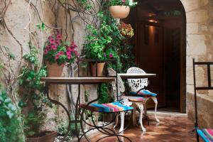 马赛马斯维勒酒店的庭院设有两把椅子和一张鲜花桌子