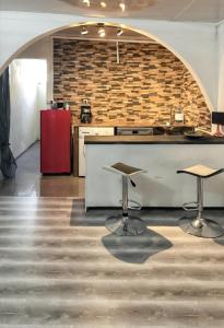 圣皮埃尔Studio avec jardin clos et wifi a Saint Pierre的厨房配有2张凳子和带红色冰箱的台面