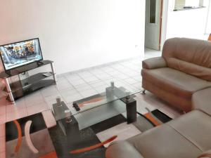 DucosAppartement de 2 chambres avec jardin clos et wifi a Ducos的带沙发和咖啡桌的客厅