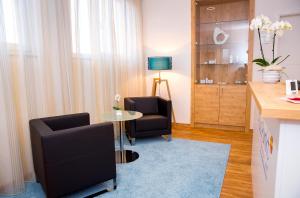 韦因加尔滕Plus Punkt Private Spa的客厅配有两把椅子和一张桌子