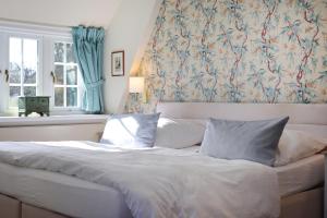 凯图姆塞勒霍夫开特姆加尼酒店的窗户间内的一张带两个枕头的床