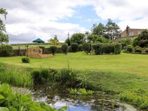奥特利Bride Cross Granary的一个带池塘和凉亭的花园