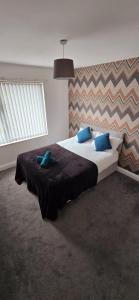 拉夫堡7 Guest 4 Bedrooms CITY CENTRE lovely home in Loughborough City Centre的一间卧室配有一张带蓝色枕头的大床
