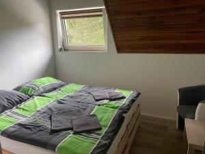 斯特拉特纳Penzión Stratenka的一张带绿色和灰色棉被的床和一个窗户
