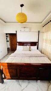阿杰隆Mustafa Farm的配有吊灯的卧室内的一张大型木床