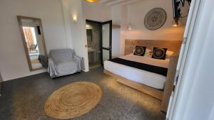 阿诺梅拉Mykonos Double Luxury Mini Suites - Adults only的一间卧室配有一张床、一把椅子和一张桌子