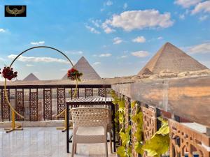 开罗Comfort Sphinx Inn的阳台配有桌椅和金字塔。