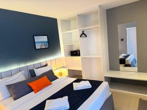 卡波布里奥Flat 218 no bairro da Passagem em Cabo Frio的一间卧室配有一张带橙色枕头的大床