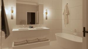 北哈特利Manoir Hovey, Relais & Châteaux的浴室设有2个水槽、浴缸和镜子