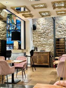 雅典Athens The L7 Str - Luxury Boutique Collection Hotel的一间带粉色椅子的餐厅和一间酒吧